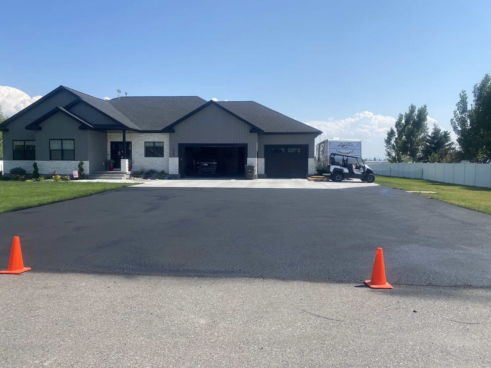 Wide freshly paved asphalt driveway at a modern ranch home near Idaho Falls