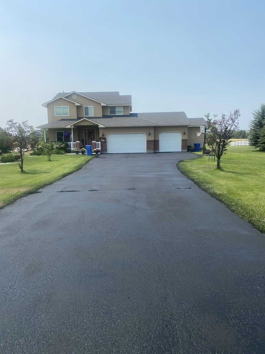 New asphalt driveway leading to a two-story rural home